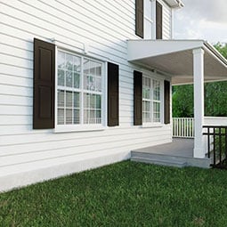 Black PVC exterior shutters mounted on a brick wall, featuring a sleek, traditional design ideal for enhancing curb appeal and weather durability.