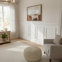 Elegant room featuring wainscot paneling and a contrasting dark furniture piece. Soft blue walls and decorative lamp add a cozy, sophisticated ambiance. Perfect for interior design inspiration.