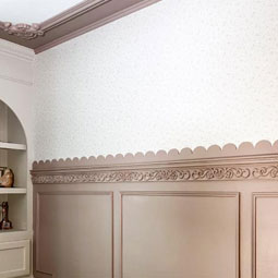 Elegant interior showcasing a decorative chair rail with scalloped edges, enhancing the wall design and adding architectural interest to the serene, softly patterned space.
