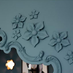 Elegant floral rosettes in a soft blue tone adorn a decorative wall, adding a touch of sophistication and artistry to the interior space. Perfect for enhancing home decor aesthetics.