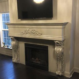 Elegant fireplace surround featuring intricate molding and classic details, enhancing the cozy ambience of a modern living space. Ideal for adding charm and character to interiors.