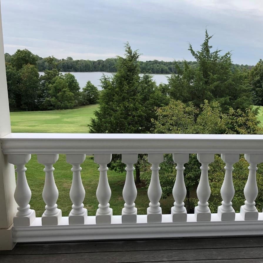 Elegant white balustrade overlooking a serene lake and lush greenery, enhancing the picturesque landscape while adding architectural charm to outdoor spaces. Ideal for enhancing scenic views and promoting safety on balconies and decks.