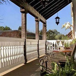Elegant outdoor balcony showcasing a beautifully designed balustrade, framed by lush greenery and warm sunlight, perfect for enhancing any architectural aesthetic.