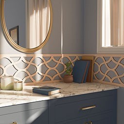 Elegant interior showcasing pierced moulding above a marble countertop. Natural light filters through a window, highlighting decorative elements and a round mirror.