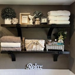 Stylish wall-mounted shelves displaying neatly folded towels, decorative plants, and tasteful accessories, creating a serene and organized space perfect for relaxation.
